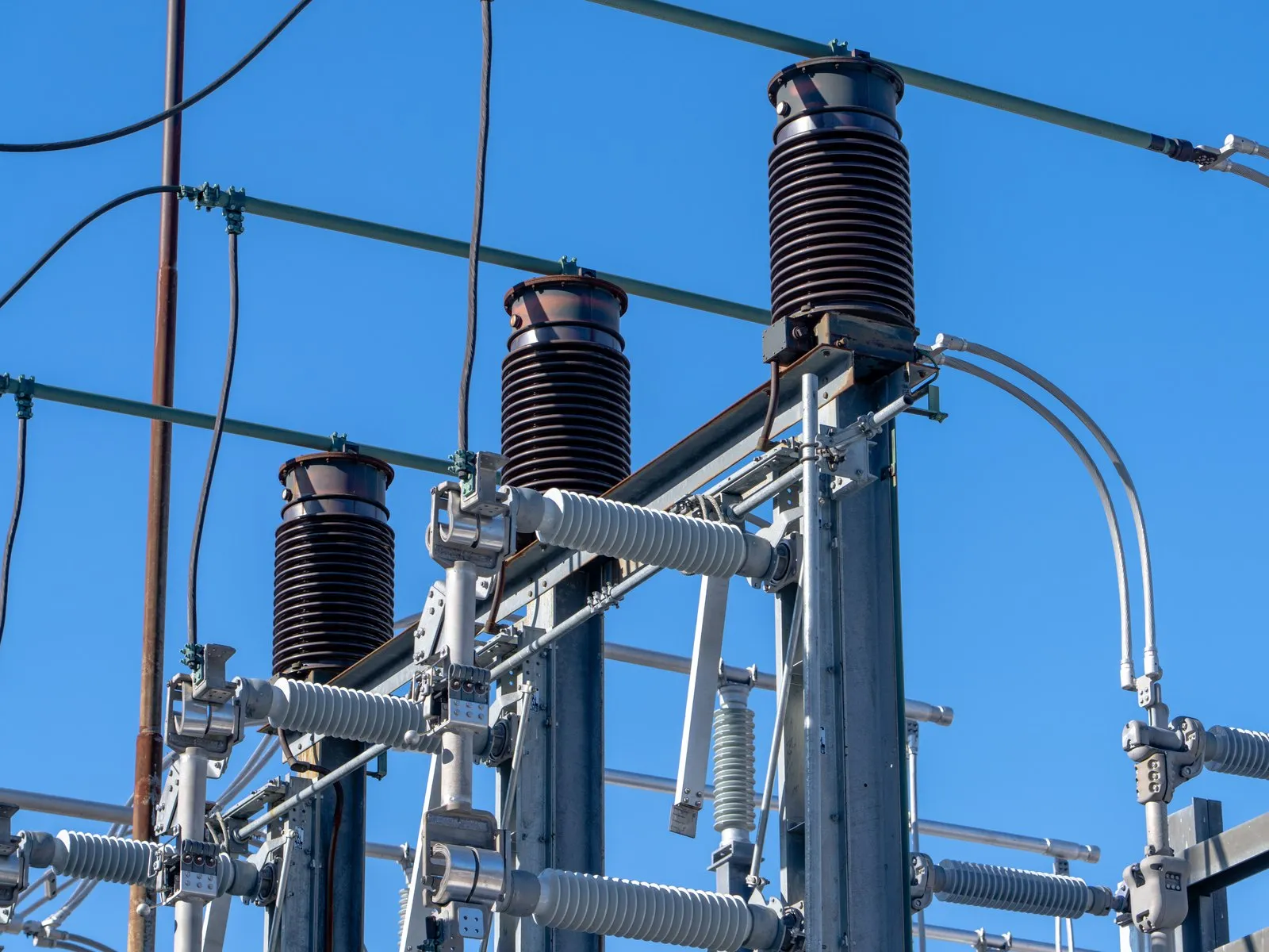 Insulators and switchgear of an HV electrical substation under a blue sky